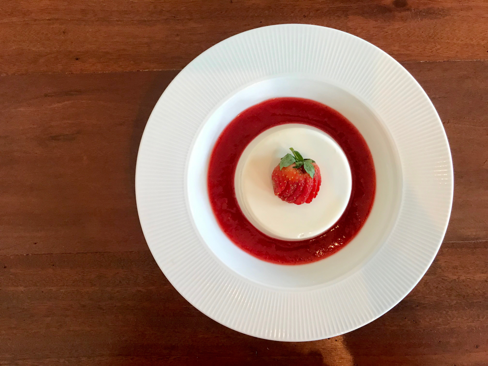 24401764 sliced strawberries in clear glass jar with cream